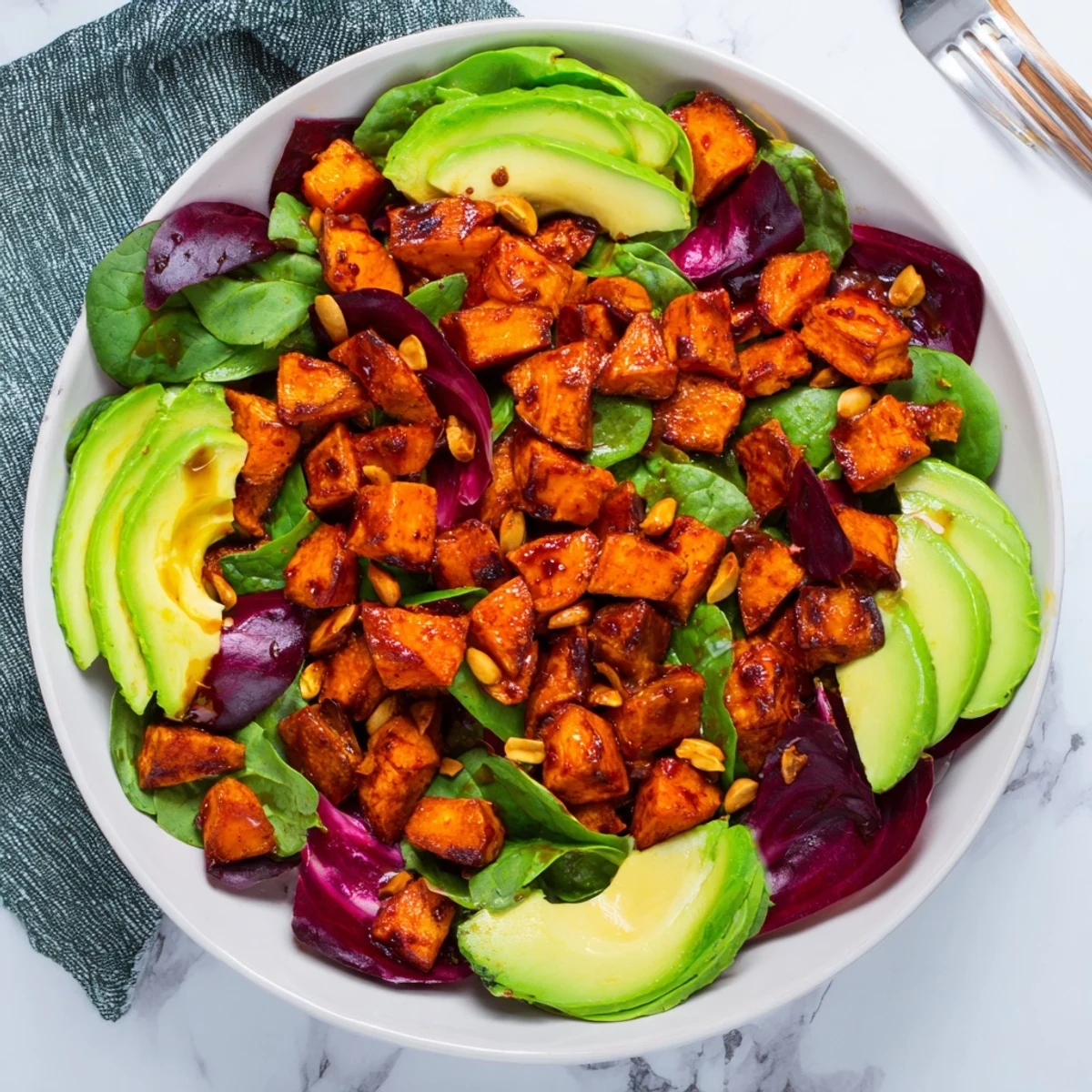 Golden-brown spiced sweet potatoes top this colorful Spiced Peanut Sweet Potato & Radicchio Salad Bowl.