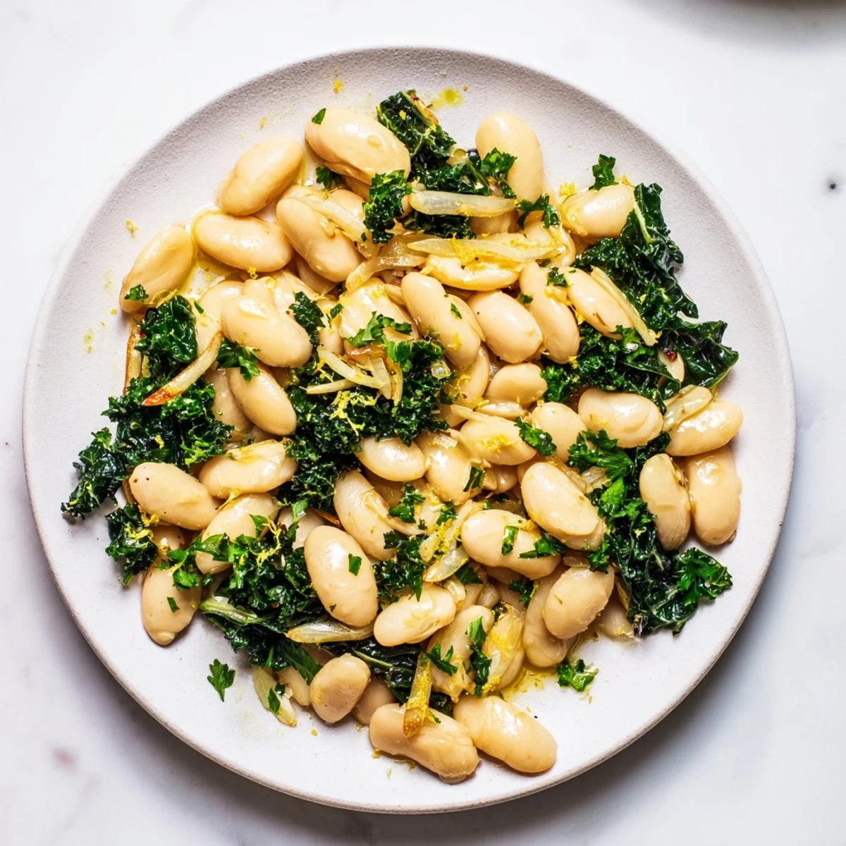 Enjoy a close-up of the garlicky beans with winter greens, ready to eat, garnished with fresh parsley.