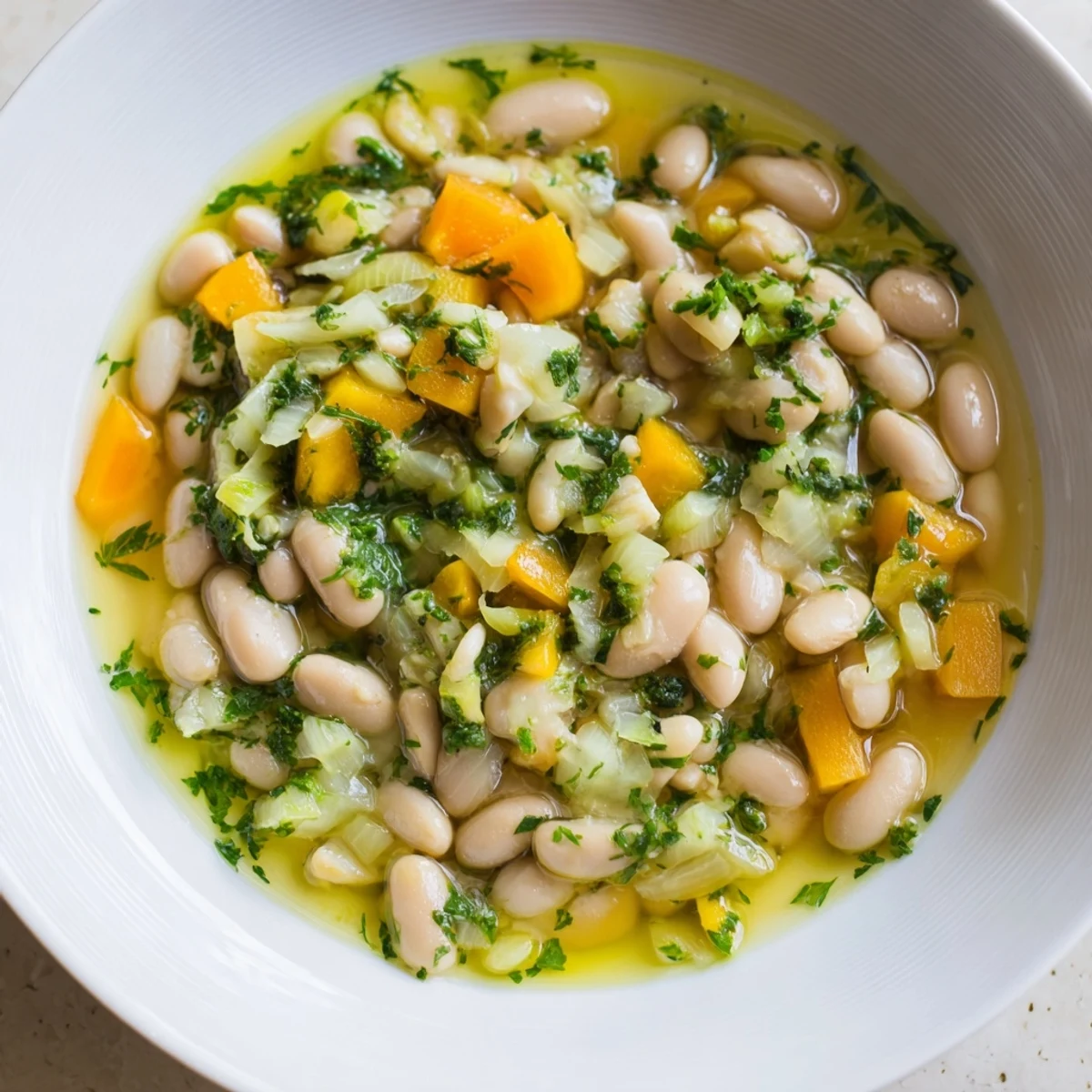 Steaming bowl of Simple White Bean and Fennel Soup garnished with fresh fennel fronds, ready to eat.