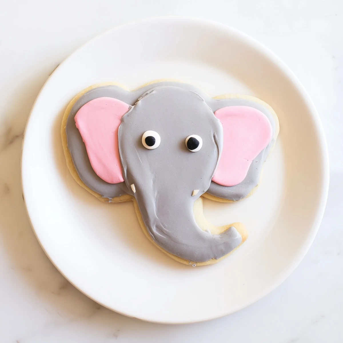 Close-up of frosted Biscuits Amical Éléphant Géant, charmingly decorated with gray, pink, and black icing.