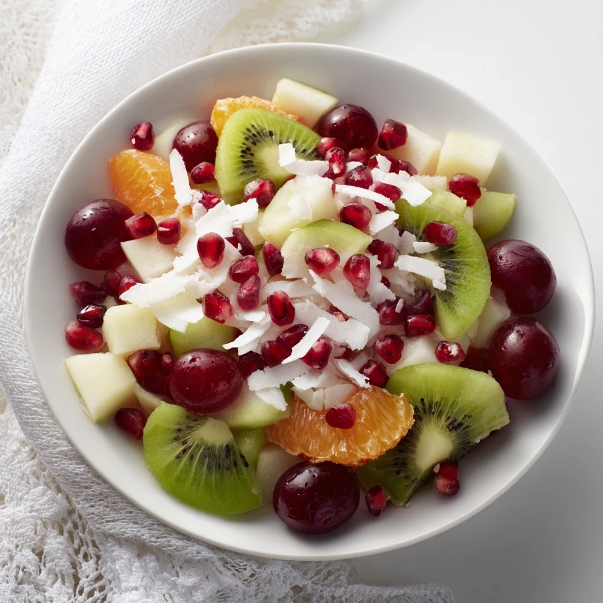 Festive Snowflake Fruit Medley: a winter dessert with diced fruit, citrus dressing, and snowy coconut.