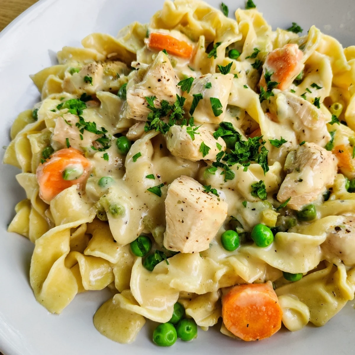 A steamy bowl of creamy chicken and egg noodles, perfect for a cozy dinner.