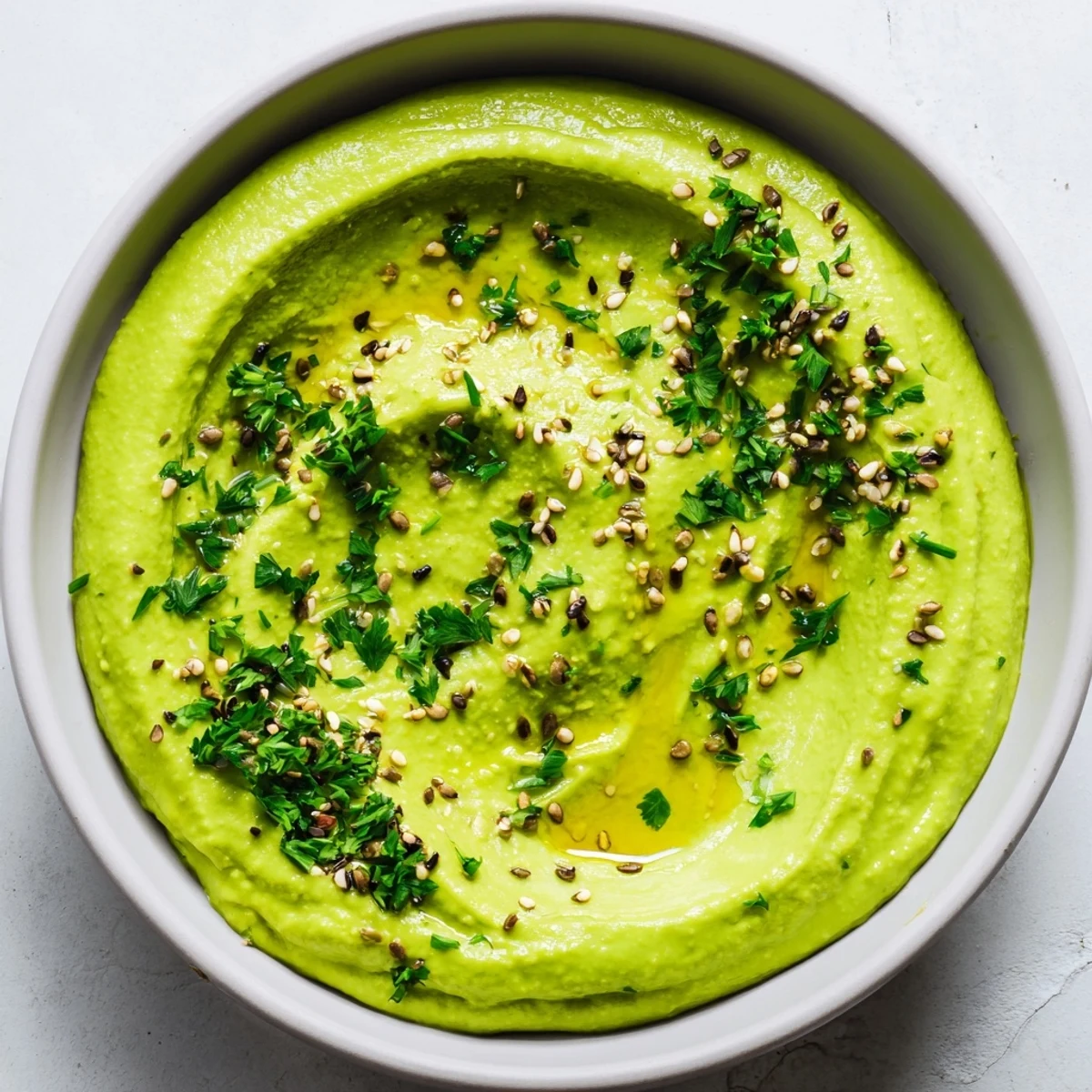 Vibrant edamame hummus dip served with crisp pita chips and colorful raw vegetables for a wholesome snack.  