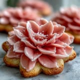 Baby in Bloom flower cookies with pastel icing arranged on a white platter for a baby shower dessert table.