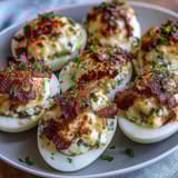 Cute deviled egg chicks with carrot beaks and peppercorn eyes, perfect for Easter brunch.