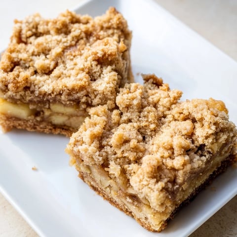 Tender Apple Cinnamon Crumble Bars topped with buttery crumbs, perfect for fall gatherings.  