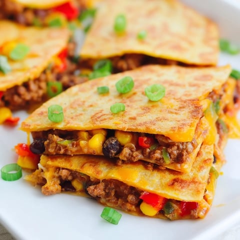 Golden-brown sheet pan quesadillas with beef brimming with melted cheese, a flavorful, easy dinner.