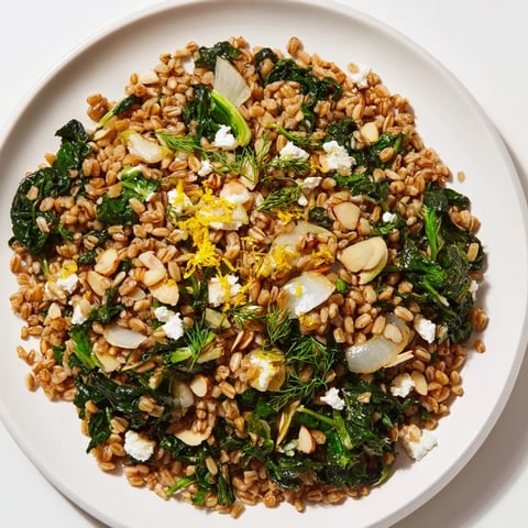 Steaming Warm Farro & Greens Pilaf glistening with olive oil and toasted almonds for dinner.