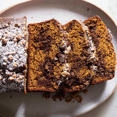 Warm, spiced pumpkin bread loaf, perfectly golden-brown and ready to be enjoyed with coffee.