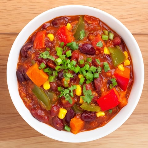 Steaming veggie chili with a rich tomato base, served in a bowl, perfect for a cozy dinner.