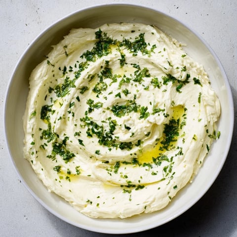 Creamy whipped feta dip photo, glistening with lemon-mint drizzle, perfect appetizer for friends.