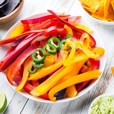 Brightly colored Spicy Chili Pepper Fiesta party platter featuring dips, chips, and fresh vegetables for dipping.