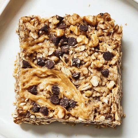Golden square of peanut butter banana oat bars, thick and studded with chocolate chips.