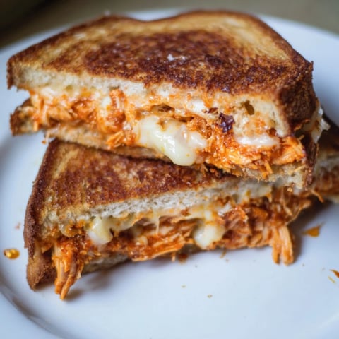 Golden brown and bubbly Chili Crisp Honey Chicken Grilled Cheese, a delicious sweet-and-spicy sandwich.