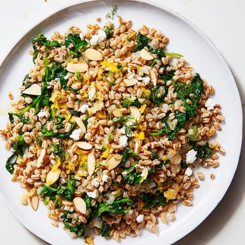 Vibrant image of a freshly made Warm Farro & Greens Pilaf, perfect vegetarian side dish.
