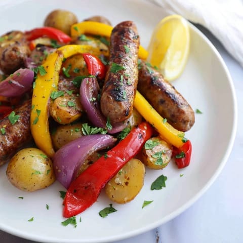 Image of Sheet-Pan Sausage with Peppers, Onions, and Potatoes; a colorful, one-pan meal, ready to eat!