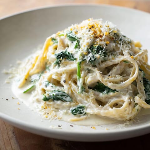 A close-up of a bowl of creamy Greek Yogurt Spinach Alfredo Pasta, boasting a rich, flavorful sauce and perfect pasta.