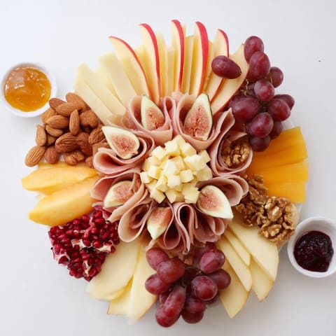 Éclat dÉtoiles Planche de Noël 2025: A starburst charcuterie board with cheeses, meats, and festive fruit arrangements.