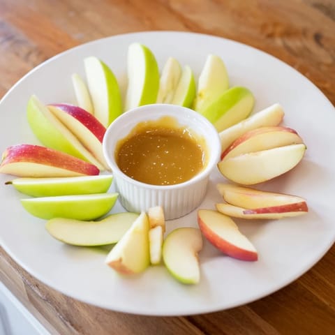 Sweet, juicy apple slices surrounding a rich, creamy caramel dip, ready to enjoy.