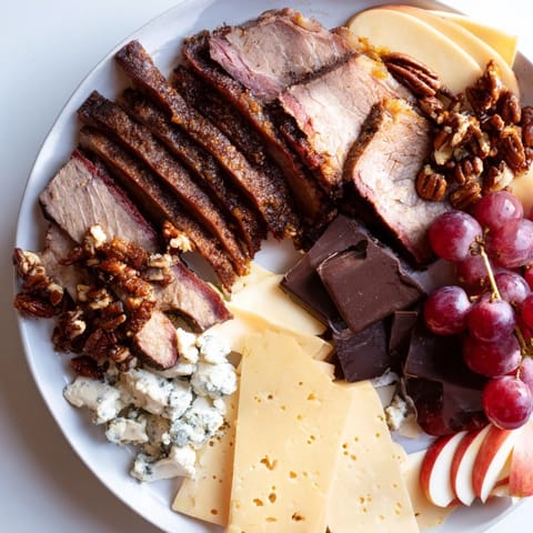 This decadent Smoky BBQ & Bourbon Companion features grilled meats, creamy cheese, and rich chocolate.