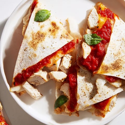Crispy tortilla pizza wrap with chicken, filled with marinara, herbs, and warm, juicy chicken pieces.