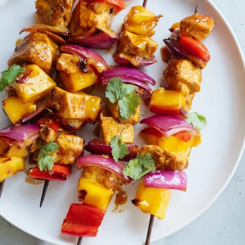 Colorful close-up of grilled mango lime chicken skewers, showcasing the tropical delight of each bite.