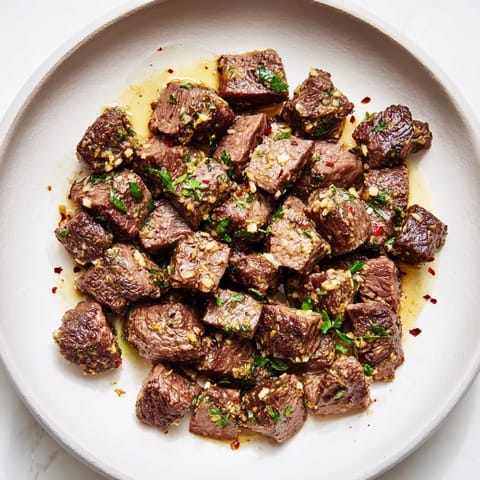 Sizzling Garlic Butter Steak Bites, perfectly seared with a sprinkle of fresh parsley, look mouthwatering.