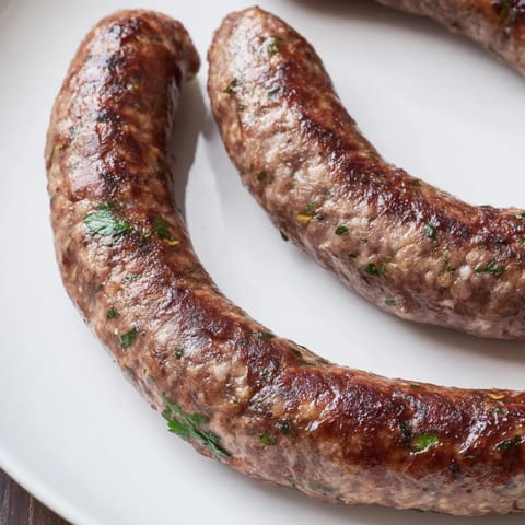 Close-up of freshly grilled Tunisian Merguez Sausage bursting with flavorful spices and herbs.