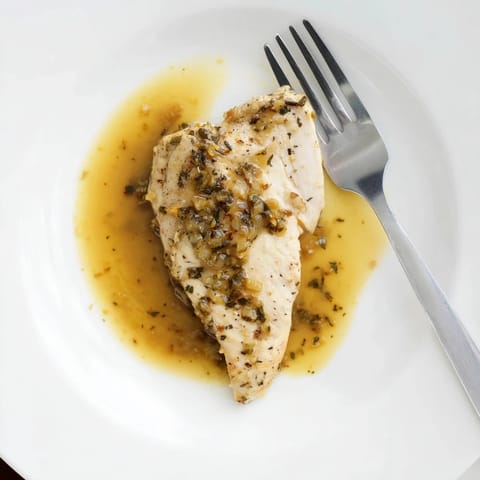 Fresh herbs garnish this Honey Dijon Chicken Skillet, with steam rising from the tender, pan-seared chicken breasts.
