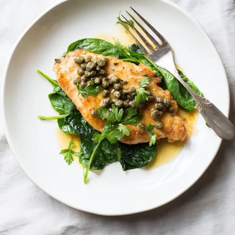 Tender golden-brown Spinach Lemon Butter Chicken, garnished with fresh parsley and lemon slices, ready to serve with rice or crusty bread.