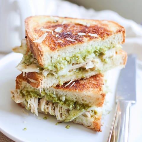 Fresh basil and vibrant pesto spread inside the toasted Mozzarella Pesto Chicken Grilled Cheese.
