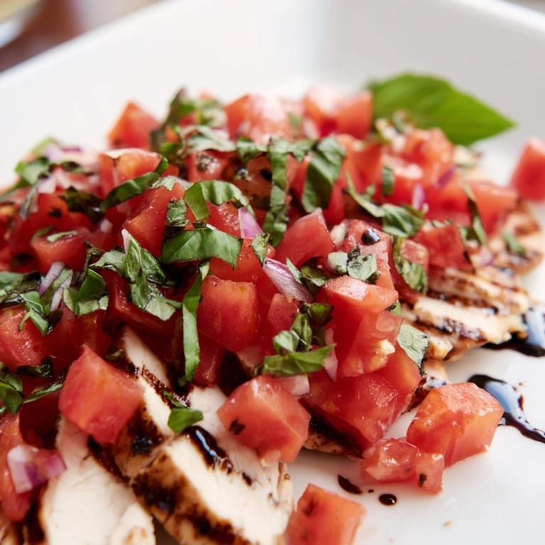 Hearty Bruschetta Chicken Salad featuring tender chicken, fresh tomato-basil bruschetta, and greens, perfect for a summery Italian-inspired dinner.