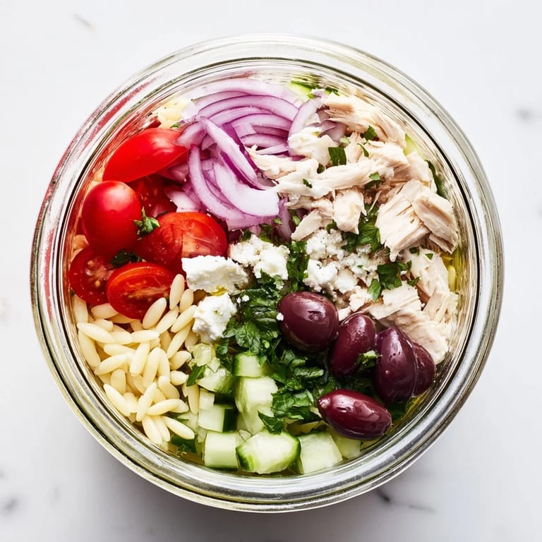 Mediterranean chicken salad jars with orzo, Kalamata olives, red onions, and fresh parsley, ideal for grab-and-go lunches.  