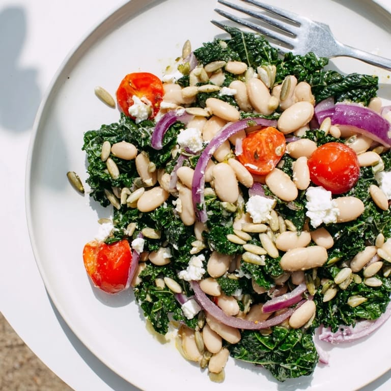 A hearty White Bean and Kale Salad served in a rustic bowl with cherry tomatoes and sunflower seeds.  