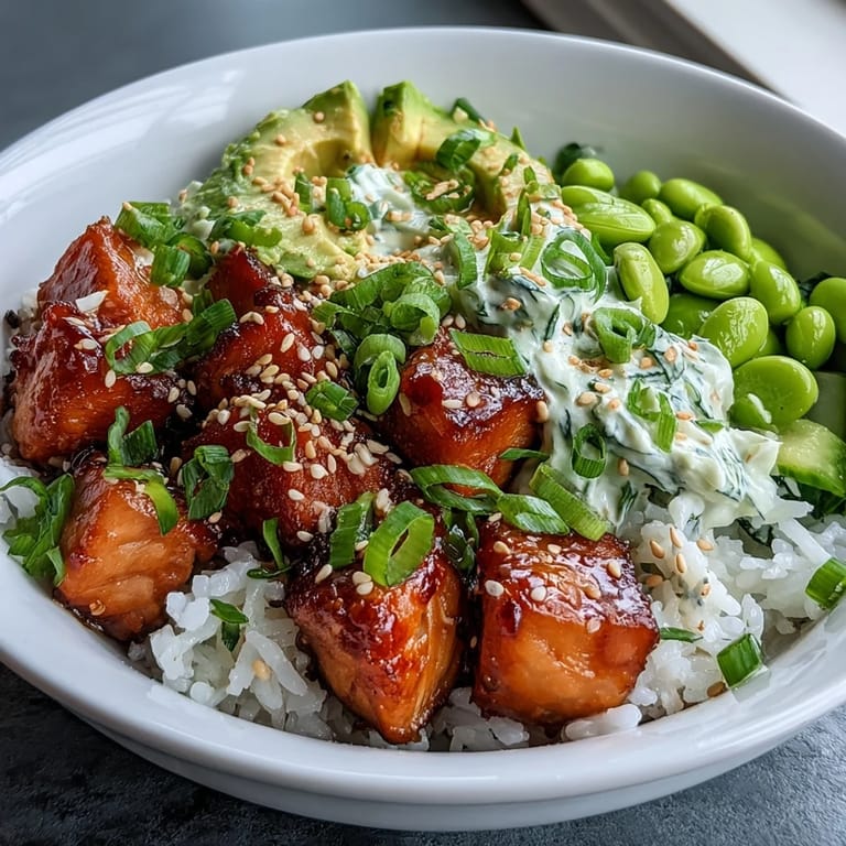 A close-up of the Salmon Rice Bowl reveals crispy salmon edges, vibrant green edamame, and creamy avocado.