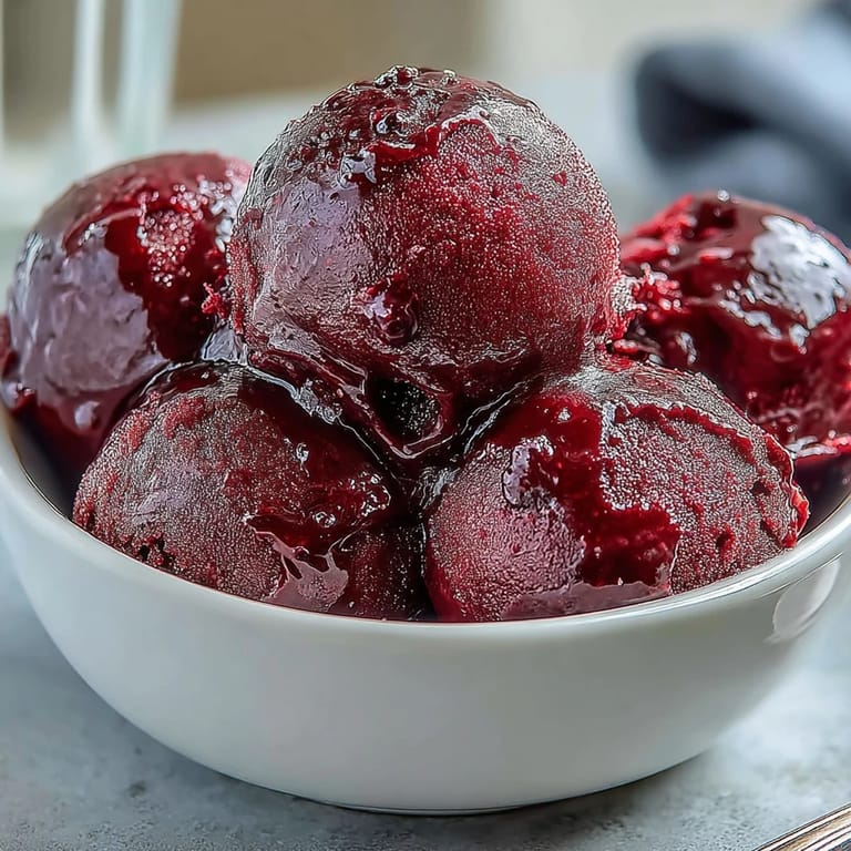 Close-up of Black Currant Sorbet showing smooth, icy crystals and berry seeds, evoking its tart, refreshing flavor.